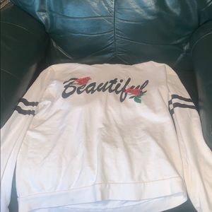 White hoodie/shirt with black writing.